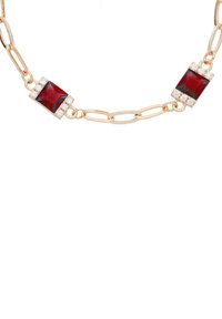 Collier en or avec deux pierres rouges rectangulaires, chacune entourée de pierres précieuses transparentes, avec des maillons allongés et une finition polie.