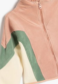 Giacca in pile con chiusura a zip, in sezioni di rosa pastello, verde e crema, con una finitura morbida e texture.