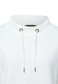 White high-neck sweatshirt with metal eyelets and white drawstrings with metal tips at neckline.