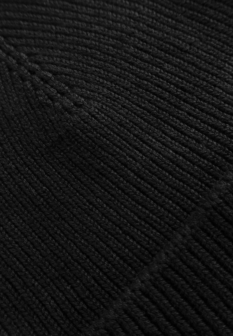 Black knitted beanie, featuring a ribbed texture, smooth finish, and seamless design. Material appears soft and thick for warmth.