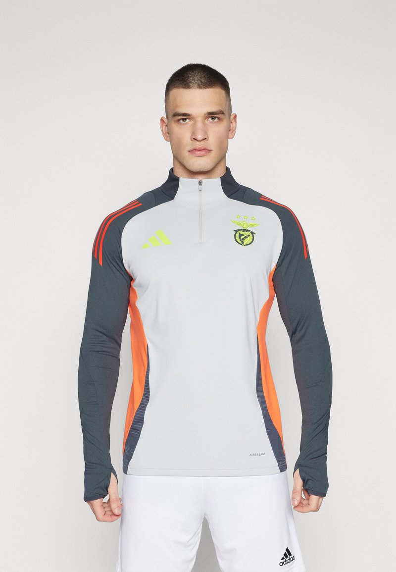 Light gray athletic long-sleeve top with dark blue and orange accents, half-zip collar, embroidered logo, and ribbed sleeve cuffs.