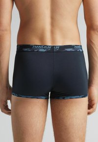 Schwarze Boxershorts mit einem blauen Camouflage-Muster am Bund, ausgestattet mit einer glatten Textur und einem enganliegenden Design.