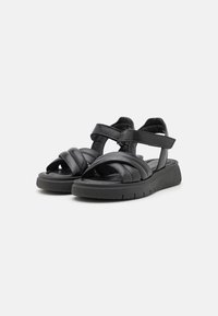 Sandales en cuir noir avec plusieurs larges brides, sangle de cheville réglable, semelle rembourrée et semelle extérieure en caoutchouc texturé pour une bonne adhérence.