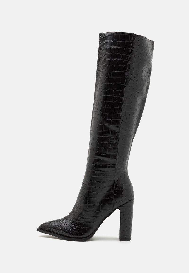 Bottes noires mi-mollet en similicuir brillant avec une texture crocodile, bout pointu et talon carré.