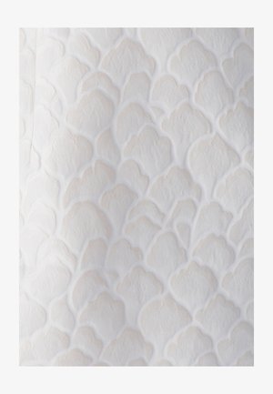 Texturovaná látka v jemně bílé barvě s vyvýšenými, scalloped vzory. Materiál se zdá být měkký s jemným leskem a reliéfními detaily.