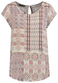 Blouse beige à manches courtes avec des motifs géométriques et floraux multicolores complexes, présentant un col rond avec une petite ouverture en forme de goutte.