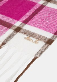 Sciarpa a scacchi con tonalità di rosa, crema e marrone, realizzata in tessuto morbido, con bordi frangiati e un dettaglio in strass "just".