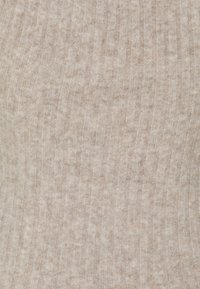 Beige ribbeltricot stof met een zachte, textuurrijke afwerking; subtiele kleurvariaties die een warme en gezellige uitstraling creëren.