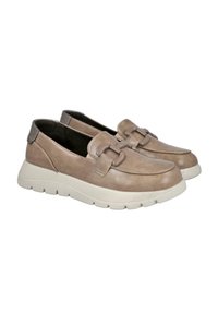 Un par de mocasines beige sin sujeción con suelas blancas gruesas y correas decorativas en la parte frontal, mostrados sobre un fondo blanco.