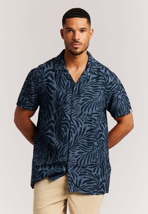 Kurzarmhemd in Marineblau mit kontrastierendem schwarzem Blattmuster. Verfügt über einen Camp-Kragen und eine Knopfleiste. Aus leichtem Stoff gefertigt.