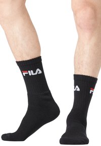 Chaussettes de sport noires à côtes avec logo brodé blanc et rouge. Design longueur cheville avec des poignets renforcés et une texture douce.