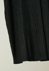 Schwarzer, strukturierteter Stoff mit einem zerknitterten Muster, das ein fließendes Design und einen unregelmäßigen Saum aufweist. Das Material wirkt leicht und weich.
