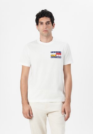 T-shirt bianca in cotone con un logo quadrato multicolore sul petto con la scritta "TOMMY HILFIGER". Maniche corte e collo rotondo.