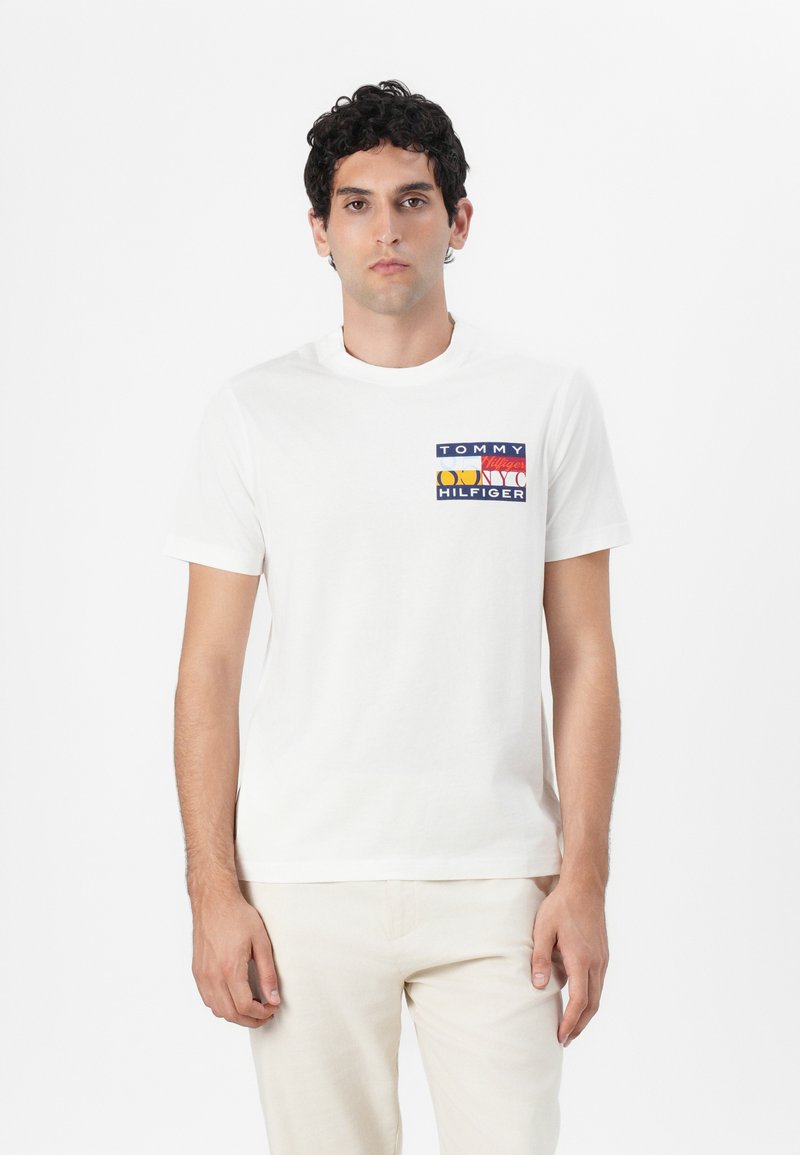 Witte katoenen T-shirt met een multikleurig vierkant logo op de borst met de tekst "TOMMY HILFIGER". Korte mouwen en een ronde hals.