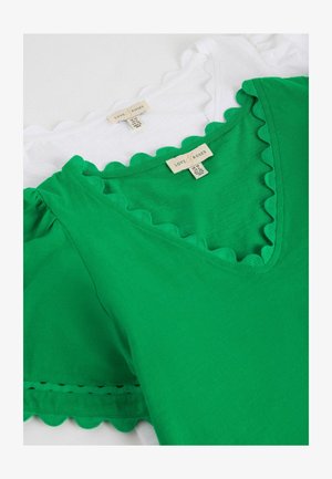 Vihreät ja valkoiset yläosat siksakreunaisilla V-pääntieillä ja pussihihoilla, pinottuina näkyvien "Love & Roses" -kokoetikettien kera.