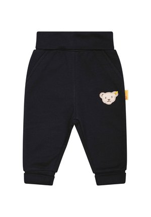 Pantalon bébé noir avec taille et poignets élastiqués, poches latérales et petit écusson beige en forme d'ourson sur la cuisse droite.