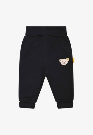 Pantalon bébé noir avec taille et poignets élastiqués, poches latérales et petit écusson beige en forme d'ourson sur la cuisse droite.