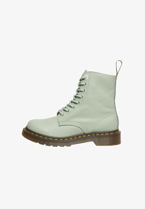 Stivaletti alla caviglia in pelle verde menta con sei occhielli, lacci e un colletto imbottito. Presentano una suola in gomma marrone con cuciture gialle e un anello sul retro.