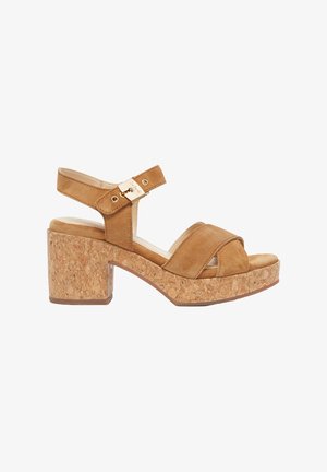 Sandali con tacco in suede beige, con una piattaforma in sughero, cinturino alla caviglia regolabile, dettaglio a fibbia dorata e design open-toe.