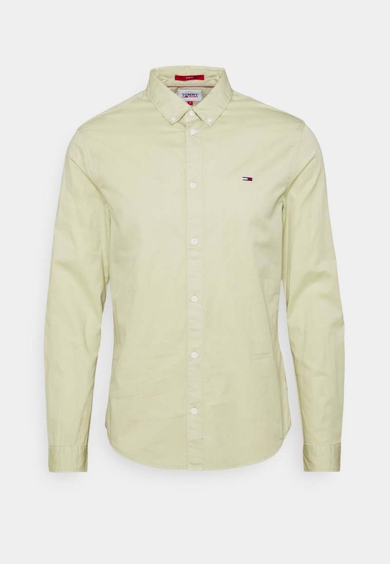 Camicia a maniche lunghe color giallo chiaro in cotone, con colletto alla camicia e una piccola patch del logo sul lato sinistro del petto.