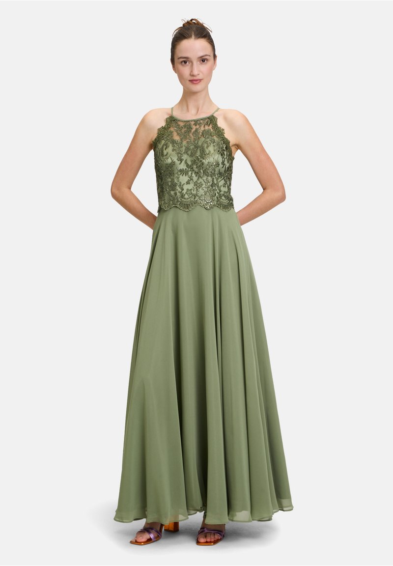 Długa oliwkowa sukienka z koronkową górą z kwiatowym haftem. Zwiewna spódnica o gładkiej teksturze i cienkimi ramiączkami.