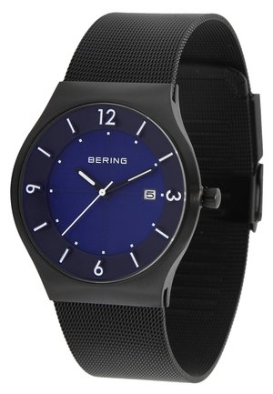 Schwarze Armbanduhr mit blauen Zifferblatt, weißen Stundenmarkierungen, Datumsanzeige auf 3 Uhr und schwarzem Mesh-Armband, die 10:10:39 anzeigt.