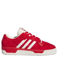 Red suede sneaker with white leather accents, featuring three white stripes, round toe, and rubber sole with textured grip.