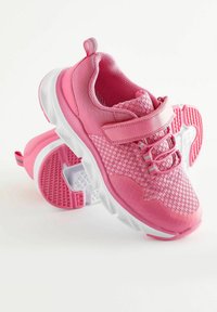 Baskets de sport roses avec une tige en tissu texturé, une sangle Velcro et une semelle rembourrée. Accents blancs et roses sur la semelle pour l'adhérence.