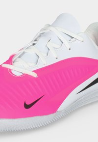 Λευκό και ροζ αθλητικό παπούτσι Nike με λευκά κορδόνια, υφασμένο πλευρικό πάνελ, μαύρο λογότυπο Swoosh και ραβδωτή σόλα.