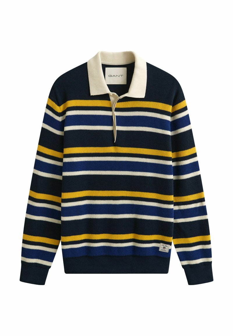 Pull en maille bleu marine avec des rayures horizontales blanches, jaunes et bleues, un col crème et une petite étiquette de marque près de l'ourlet.