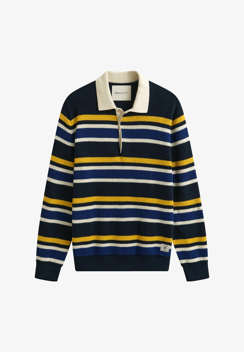 Suéter de punto azul marino con rayas horizontales en blanco, amarillo y azul, cuello crema y una pequeña etiqueta de la marca cerca del dobladillo.