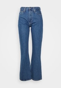 Blå denimflarejeans med hög midja, med knappstängning, fem-ficksdesign och en medeltvätt. Skräddarsydd passform vid höften.