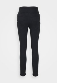 Jeans skinny negros con cintura alta, que cuentan con dos bolsillos traseros con estampado de hojas en relieve y herrajes decorativos.