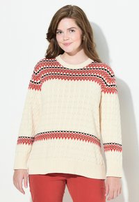 Maglione lavorato a maglia beige con un motivo testurizzato, caratterizzato da una fascia geometrica rossa e nera attraverso il petto e maniche lunghe.