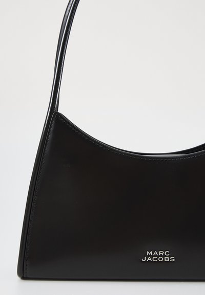 Sac à main en cuir noir avec un design courbé, présentant une texture lisse et une fine bandoulière. Détail du logo "Marc Jacobs" en argent en bas.