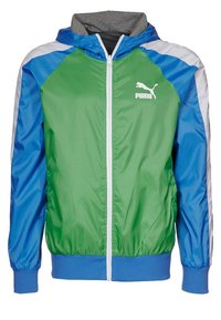 Grön och blå vindjacka med en grå huva, vit dragkedja och PUMA-logotyp. Har elastiska ärmslut och nederkant för en säker passform.