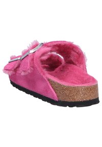 Pink suede slipper with fluffy accents, cork midsole, and black rubber outsole. Open back design and decorative bow detail.