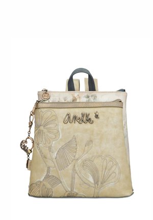 Beige Rucksack mit floralem Reliefdesign. Verfügt über zwei Schulterriemen, einen oberen Tragegriff und einen metallischen Reißverschluss mit einem Anhänger.