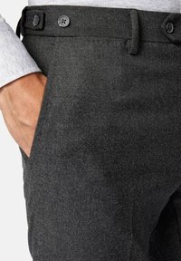 Grå ullbyxor med två knappar i midjan, en sidaficka och ett texturerat tyg med ett subtilt melerat mönster.