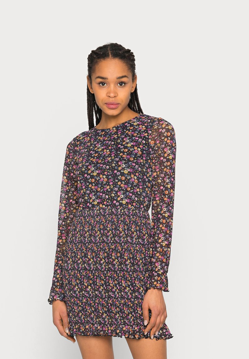 Vestido com estampa floral, com um design de mangas longas transparentes, fundo preto, flores coloridas, cintura franzida e detalhe em bordado na barra.