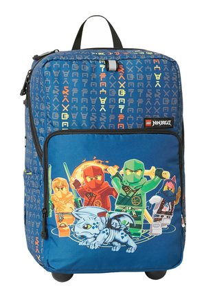 Sac à dos LEGO Ninjago bleu avec des personnages ninja et un petit dragon sur la poche avant, roulettes et fond à motifs.