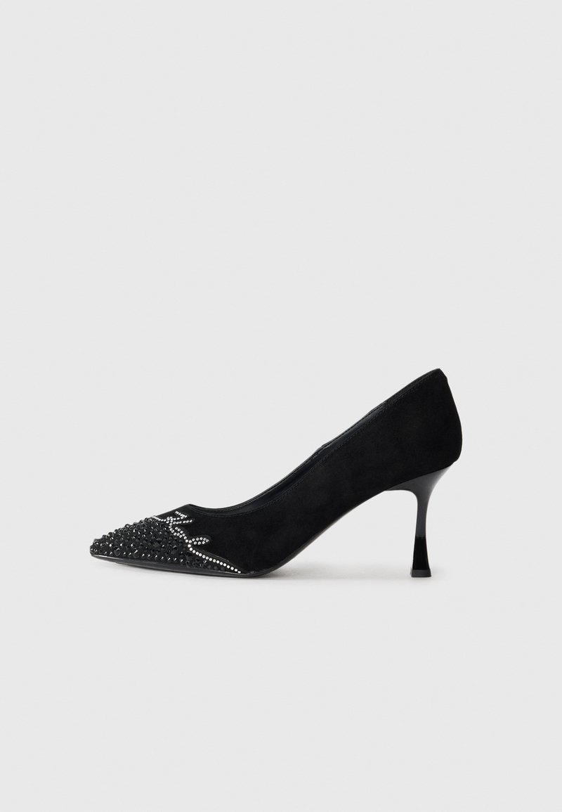 Black suede high-heeled pump with pointed toe, embellished bezel and crystal detailing at the toe cap, featuring a sleek, slender heel.