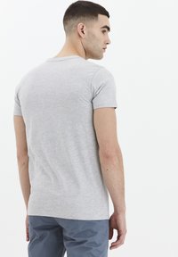 Tricou cu mânecă scurtă, de culoare gri deschis, fabricat din bumbac. Prezintă un guler tip crew neck, design ajustat și o textură moale, cu un finisaj simplu.