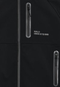 Czarna kurtka o gładkiej fakturze, z dwiema kieszeniami na zamek błyskawiczny z odblaskowymi akcentami. Na przodzie znajduje się nadruk "HALO 196819721981".