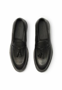 Crne kožne mokasine s teksturiranom površinom, ukrašene dekorativnim resicama i dizajnom s okruglim prstima. Glatke potplate za udobnost.