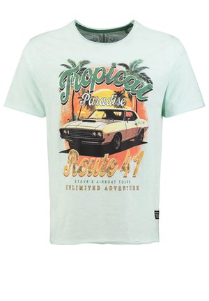 Camiseta verde claro con ilustración de coche vintage, palmeras, atardecer y texto "Ruta 41 Paraíso Tropical Tours en hidrodeslizador de Steve".