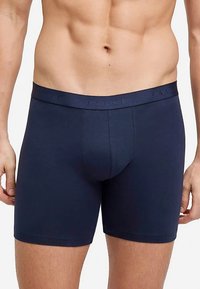 Męskie bokserki w kolorze granatowym o gładkiej fakturze, z elastycznym paskiem z napisem „FALKE” oraz dopasowanym krojem, podkreślające komfort i wsparcie.