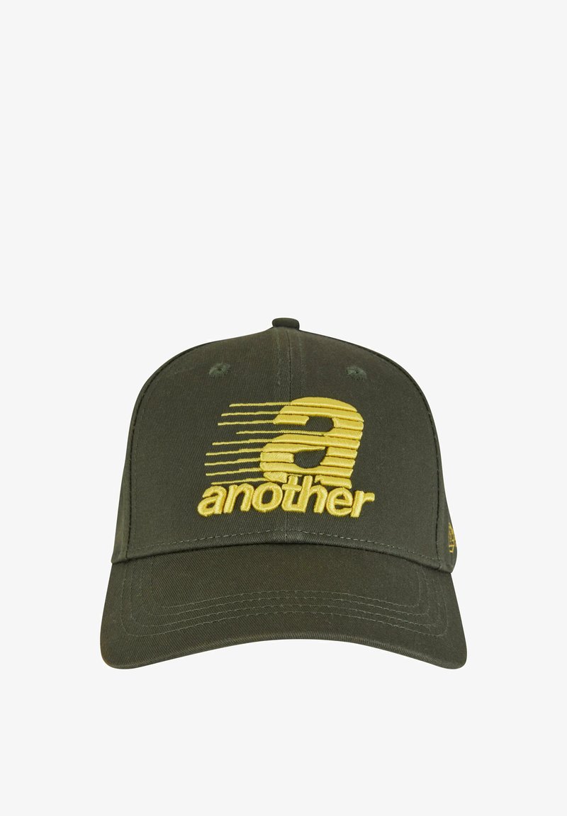 Olīvzaļš beisbola cepure, izgatavota no kokvilnas, ar teksturētu dzeltenu izšūtu logotipu "a another" un horizontāliem svītru dizainiem priekšpusē.