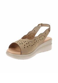 Sandal beige con design a ritagli e piccoli motivi triangolari, con punta aperta e cinturino regolabile, dotata di una suola a cuneo imbottita.