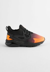 Baskets de sport noires et orange avec une tige lisse, une semelle texturée et des accents mouchetés, présentant un bout rond et un design à lacets.